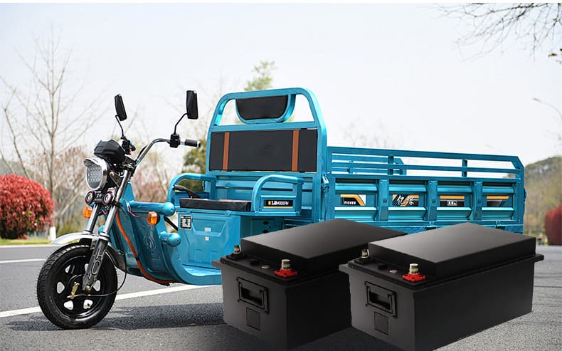 An electric vehicle parked on the road with two lithium batteries displayed in front of the car for product demonstration.
