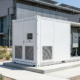 A modern outdoor container energy storage system enclosure with integrated HVAC cooling pathways installed on a concrete foundation pad.