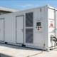 A premium white 20ft containerized 1MW battery storage solution installed outdoors on a reinforced concrete pad.