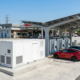 An outdoor battery energy storage for EV charging stations system integrated next to high-power dispensers.