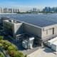 High-efficiency solar panels installed on a factory roof integrated with outdoor energy storage cabinets for comprehensive industrial solar battery storage.