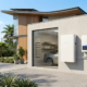 Modern residential solar battery storage with lithium ion battery storage setup on a luxury home garage wall.