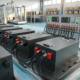 Heavy-duty commercial 48v lithium ion battery packs with matte black metal enclosures and smart status screens for industrial fleets.
