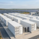 A high-density solar farm battery storage system installed next to a large-scale photovoltaic power plant.