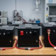 Three LiFePO4 electric tricycle battery packs in 48V, 60V, and 72V configurations side by side on a workbench