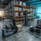 Electric forklifts operating inside a modern European warehouse with industrial battery charging systems